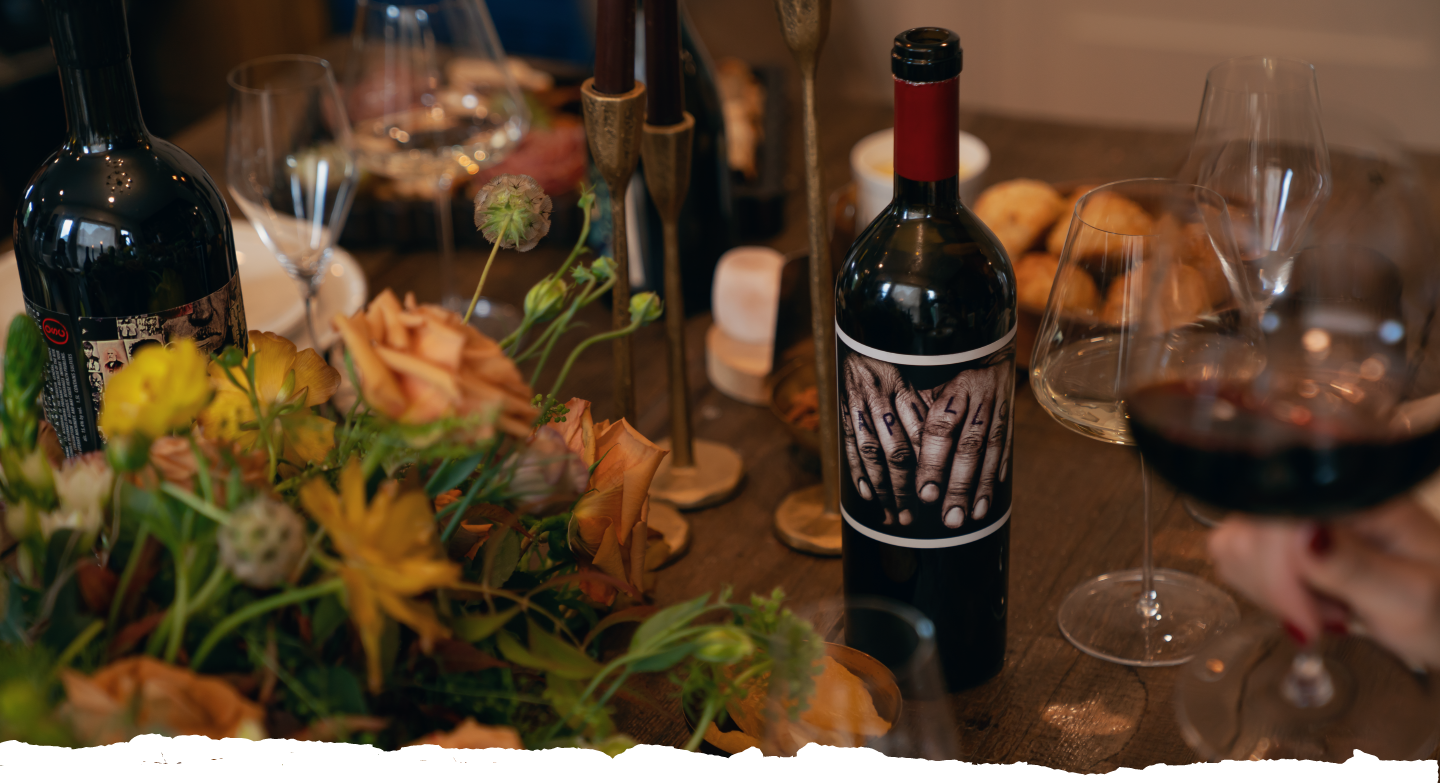 A thanksgiving table centered around an open bottle of Papillon.
